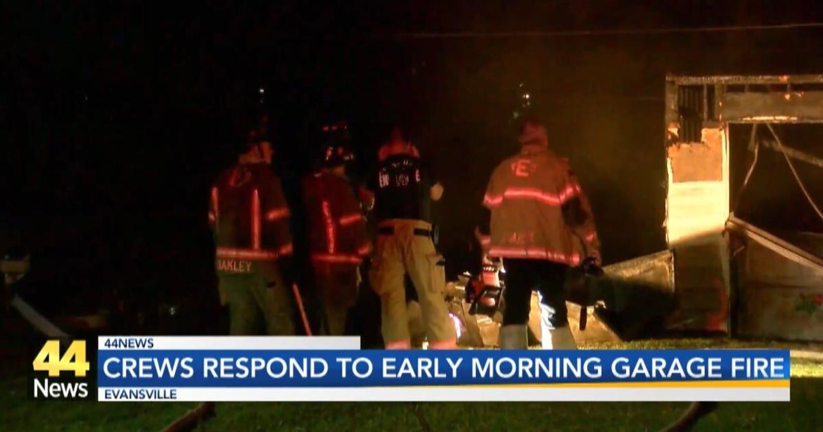 Evansville fire crews work to keep a garage fire from spreading to a nearby home | Video